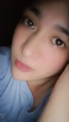 Close-up selfie of a person resting their head on their hand