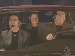 Three men laughing hysterically in a car