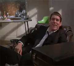 Jim Carrey laughing in a leather chair