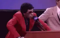 Little Richard speaking at a podium