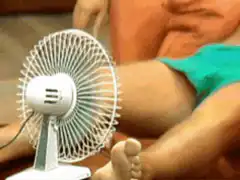 Man relaxing on couch with fan