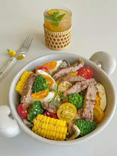 bowl of steak salad with corn and egg