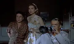 Man with camera looking at women