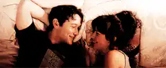 Joseph Gordon-Levitt and Zooey Deschanel laughing in bed
