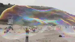 Giant iridescent soap bubble on beach