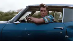 Jim Carrey as Hank Pym driving and using binoculars