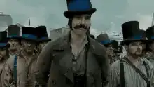 Sacha Baron Cohen as Borat tipping his hat