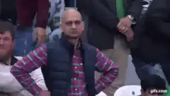 Bald man in vest looks around