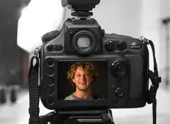 Camera screen shows smiling man