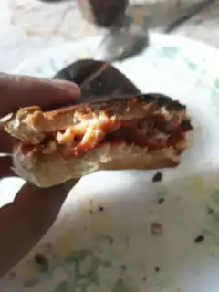 hand holding half-eaten sandwich