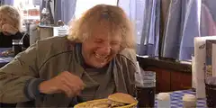 Old man laughing at food