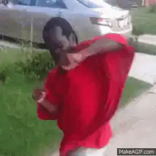 Man in red shirt dancing on sidewalk