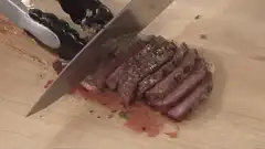 Slicing rare steak on cutting board