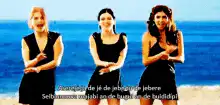 Three women singing on beach