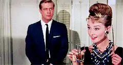 Holly Golightly offers a drink to a man