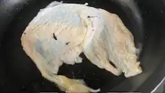 raw chicken breast in frying pan