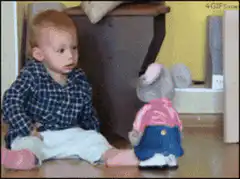 Baby laughing at toy elephant
