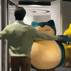 Man hugs Snorlax and Pikachu
