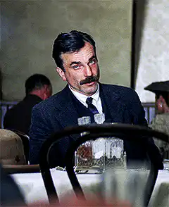 Man in suit smiles and looks down