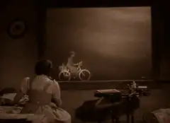 Woman watching man on bicycle on screen