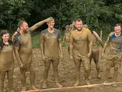 Mud covered people at an obstacle race