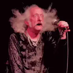 Man with wild hair singing into microphone