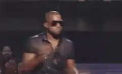 Kanye West shrugging on stage