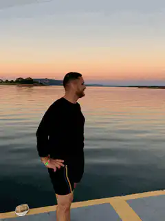 Man turns around on dock at sunset