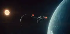 Starship Enterprise flies past a planet