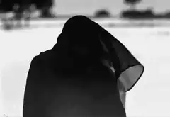 Woman in black veil in snow