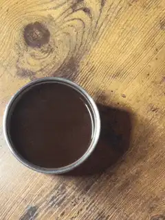 chocolate milk in metal cup on wood