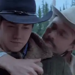 Two cowboys hugging in the woods