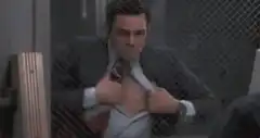 Man pulls open shirt to reveal gun
