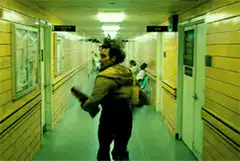 man running down yellow hallway