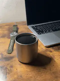 Coffee cup on desk with laptop and watch
