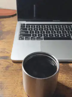 coffee cup in front of laptop
