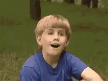 Blonde boy in blue shirt making funny faces