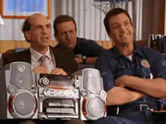 Three men fist bumping over a boombox