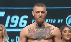 Conor McGregor flexes and raises arms