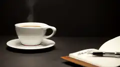 Steaming coffee cup and notebook