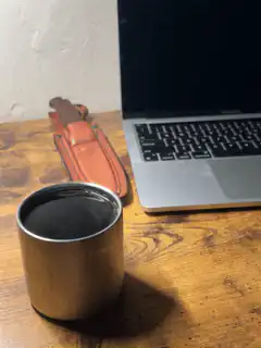 coffee cup on desk next to laptop