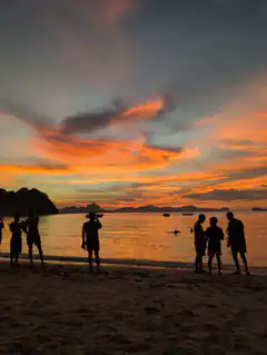 silhouettes watching sunset over ocean