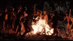 Boys dancing around a fire