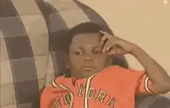 Boy in orange hoodie on plaid couch