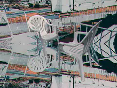 two white plastic chairs on a balcony
