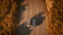 aerial view of two cars driving on a road