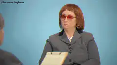 Woman in red glasses and suit looking unimpressed