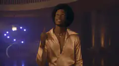 Man in gold shirt making hand gestures