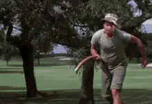 Man swinging garden hose in park