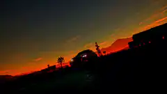 car silhouette sunset road
